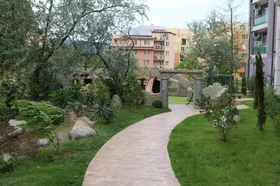 a walkway through a garden in a city at Private Apartments in Harmony Suites Dream Island in Sunny Beach