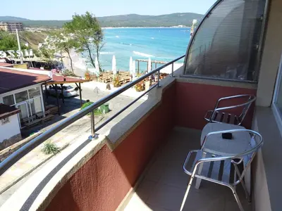 a balcony with a chair and a view of the ocean at Dobrevi Guest House in Primorsko