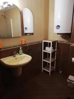 a bathroom with a sink and a mirror and a shelf at Comfort Zamenhof in Varna City