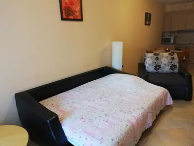 a bedroom with a bed and a chair at Comfort Zamenhof in Varna City