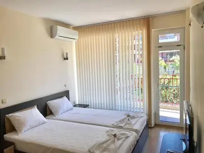 two beds in a room with a window at Jane Guest House in Nesebar