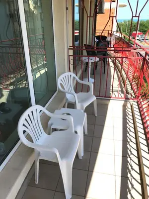 two white benches sitting on the porch of a building at Jane Guest House in Nesebar