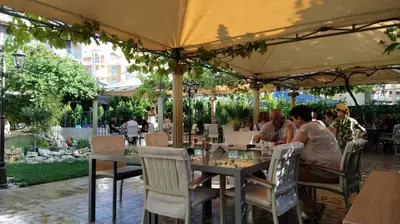 a group of people sitting at a table under an umbrella at Hotel Shipka Beach in Sunny Beach