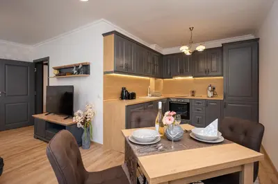 a kitchen with a wooden table and a dining room at Prestige Central Apartments in Varna City