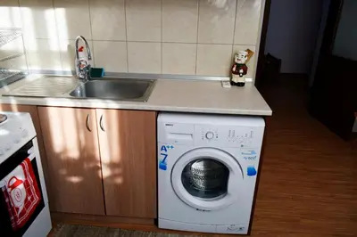 a kitchen with a washing machine and a sink at Sea Garden in Burgas City