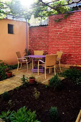 a patio with a purple table and chairs next to a brick wall at Sea Garden in Burgas City