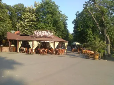 a restaurant with tables and chairs on a street at Sea Garden in Burgas City