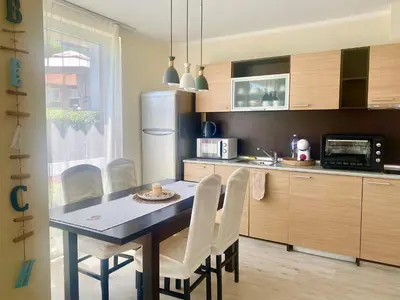 a kitchen with a table and chairs and a refrigerator at Apartments in Sunny Island Complex in Chernomorets