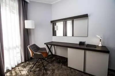 a desk with a mirror and a chair in a room at Best Western PLUS Premium Inn in Sunny Beach