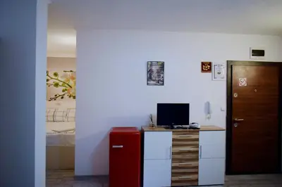 a room with a desk with a red refrigerator at Flora Beach Apartaments in Burgas City