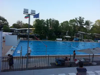 a large swimming pool with people standing around it at Flora Beach Apartaments in Burgas City