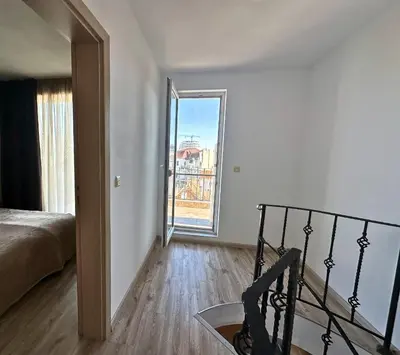 a bedroom with a bed and a balcony with a view at Maisonette Sevastiyan in Varna City