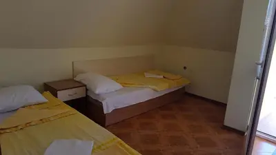a small bedroom with two beds and a window at Villa Krisia Apartments in Sozopol