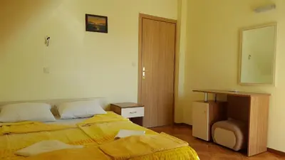 a bedroom with a bed and a table and a mirror at Villa Krisia Apartments in Sozopol