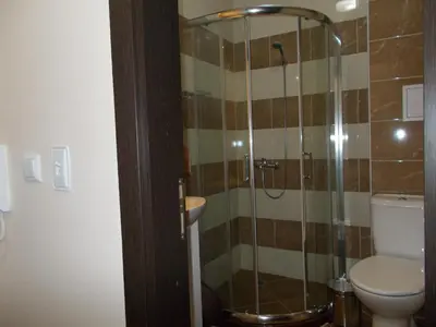 a bathroom with a toilet and a glass shower at Apartment Bliznaci in Pomorie