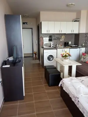 a kitchen and a living room with a table and a kitchen at Apartment Bliznaci in Pomorie