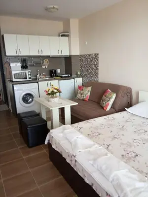 a living room with a bed and a couch and a table at Apartment Bliznaci in Pomorie