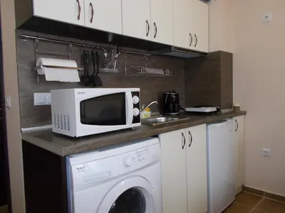 a kitchen with a washing machine and a microwave at Apartment Bliznaci in Pomorie