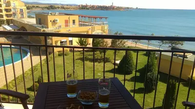 a table with two glasses of beer on a balcony at Apartament Aheloy in Aheloy