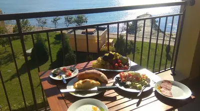 a table with plates of food on a balcony at Apartament Aheloy in Aheloy