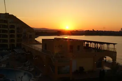 a sunset over a body of water with a building at Apartament Aheloy in Aheloy