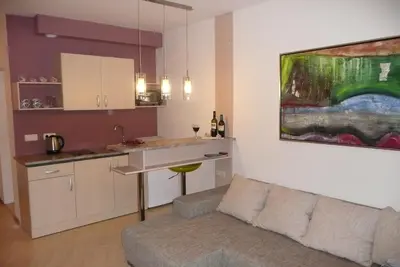 a living room with a couch and a kitchen at Apartament Aheloy in Aheloy