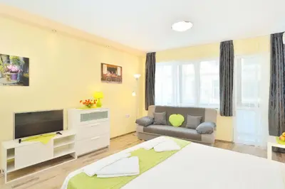 a bedroom with a large bed and a couch at Central studio 1 in Burgas City