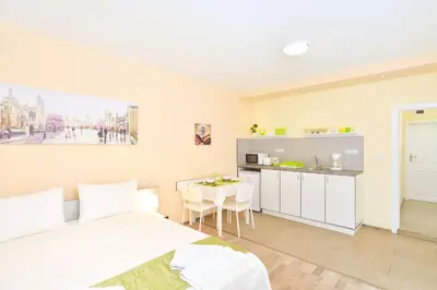 a bedroom with a bed and a kitchen with a table at Central studio 1 in Burgas City
