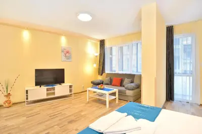 a living room with a couch and a flat screen tv at Central studio #2 in Burgas City