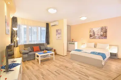 a bedroom with a bed and a couch at Central studio #2 in Burgas City