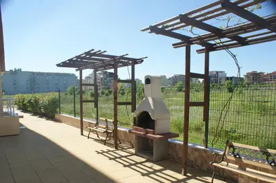 a patio with a pizza oven with two benches at Pearl Sunshine Appartments in Primorsko