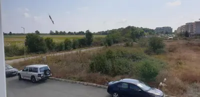 a white truck and a car on a road at Pearl Sunshine Appartments in Primorsko