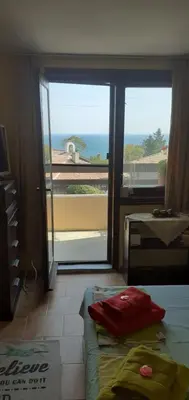 a room with a bed and a view of the ocean at Kraybrezhna 3 in Pomorie