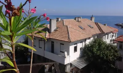 a white house with the ocean in the background at Kraybrezhna 3 in Pomorie