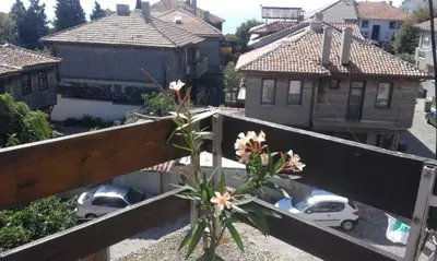 a flower on a fence with houses and cars at Kraybrezhna 3 in Pomorie