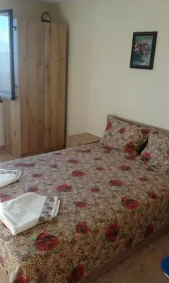a bedroom with a bed with a flowered comforter at Kraybrezhna 3 in Pomorie