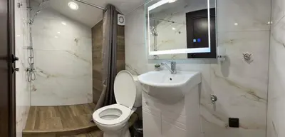 a white bathroom with a toilet and a sink at Guest House SG-BROTHERS in Obzor