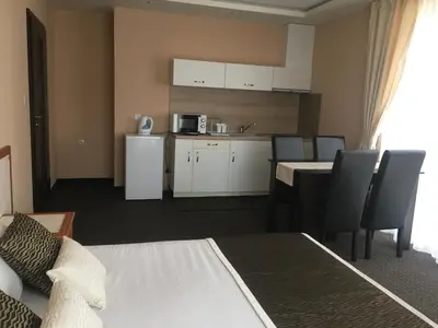 a room with a kitchen and a table and chairs at Guest House SG-BROTHERS in Obzor
