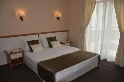 a bedroom with a bed and a large window at Guest House SG-BROTHERS in Obzor