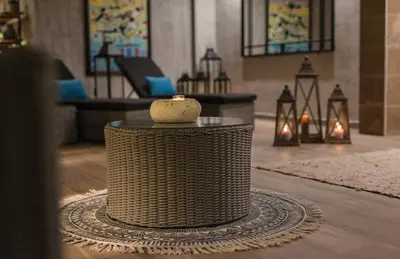 a wicker table with a candle on it in a room at Blu Bay Hotel Sozopol in Sozopol