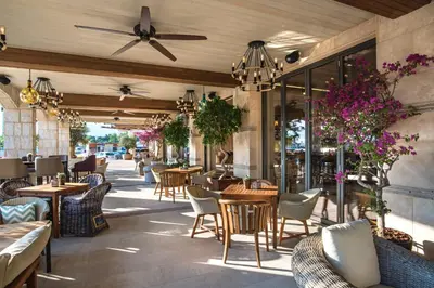 a restaurant with tables and chairs and windows at Blu Bay Hotel Sozopol in Sozopol