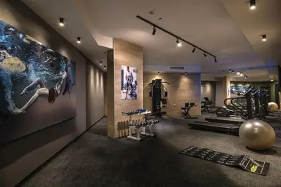 a gym with exercise equipment and a large painting on the wall at Blu Bay Hotel Sozopol in Sozopol