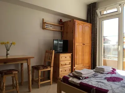 a bedroom with a bed and a desk and a television at Studio Martin in Pomorie