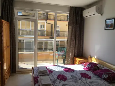 a bedroom with a bed and a large window with a balcony at Studio Martin in Pomorie