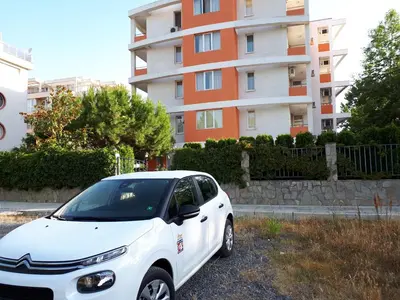 a white car parked in front of a building at Abelia Residence Apartment Regina in Sunny Beach