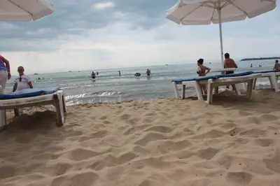 a group of people on a beach with umbrellas at Abelia Residence Apartment Regina in Sunny Beach