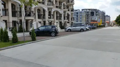 a row of cars parked in front of a building at Harmony Suites Apartment in Sveti Vlas