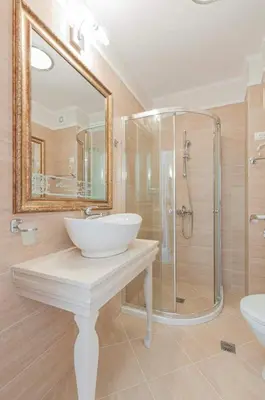 a bathroom with a sink and a glass shower at Harmony Suites Apartment in Sveti Vlas