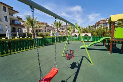 an empty playground with swings and a swing set at Burgas Beach Resort Apartments in Burgas City