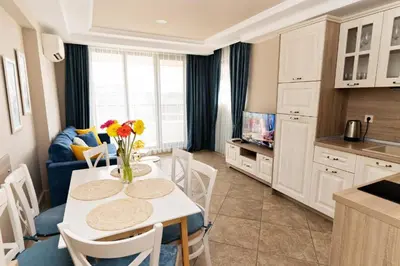 a kitchen and dining room with a table and chairs at Burgas Beach Resort Apartments in Burgas City